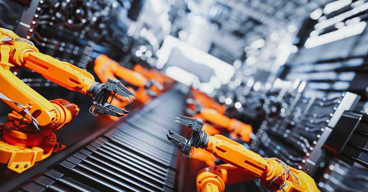 Close-up of yellow robotic arms at work on an automated assembly line in a high-tech industrial factory.