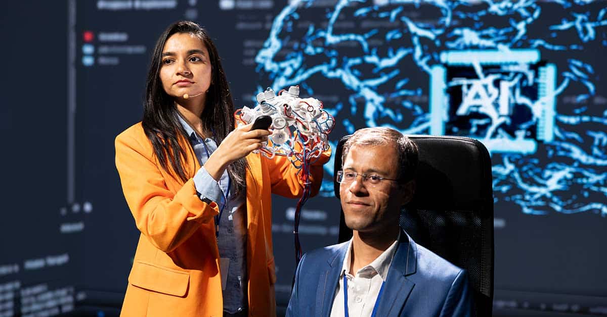 A woman holds a brainwave monitoring device near a seated man's head, as a digital brain diagram and prominent "AI" text appear on the screen in the background, highlighting advanced AI technology in action.