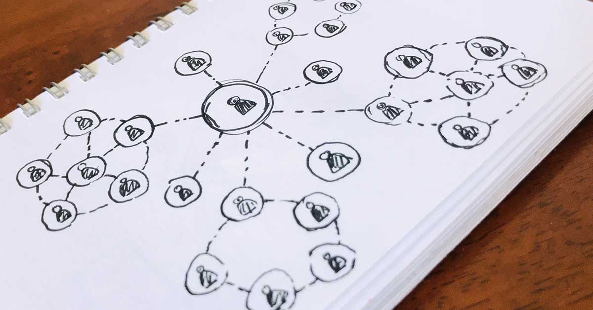 A hand-drawn diagram on paper shows connected clusters of circles, each containing a small bee, representing a data-driven network structure or organization chart.