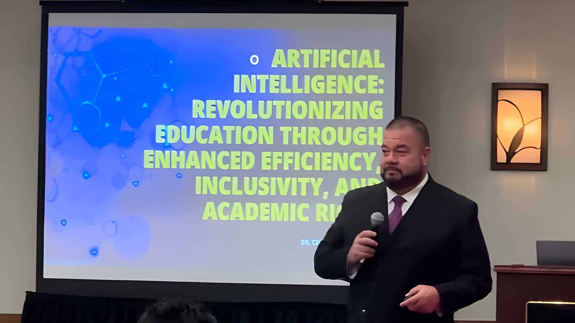 A person in a suit stands in front of a screen displaying a presentation titled "Artificial Intelligence: Revolutionizing Education Through Enhanced Efficiency, Inclusivity, and Academic Rigor.